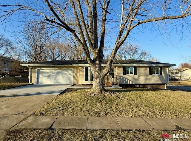 ranch-style home featuring a garage, driveway, and fence