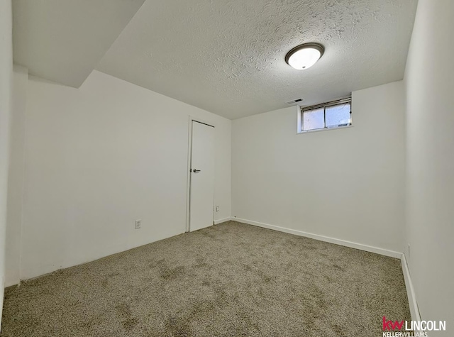 carpeted spare room featuring a textured ceiling and visible vents