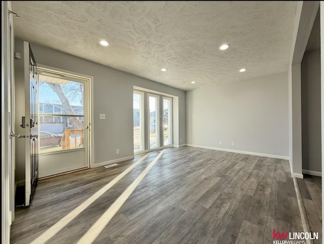 interior space featuring plenty of natural light, dark wood finished floors, and baseboards