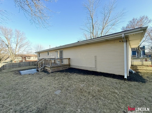 back of house featuring fence and a wooden deck