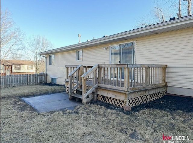 rear view of house featuring fence and a wooden deck