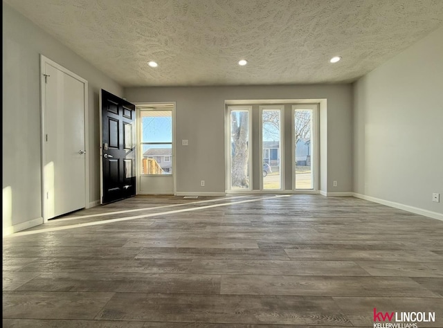 interior space with recessed lighting, a healthy amount of sunlight, baseboards, and wood finished floors