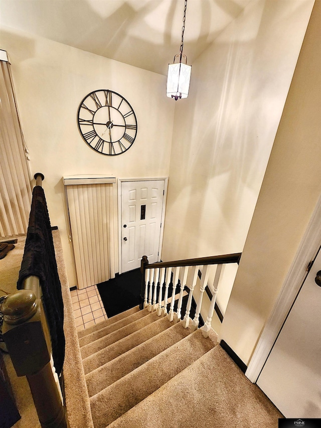 staircase with carpet floors and a towering ceiling