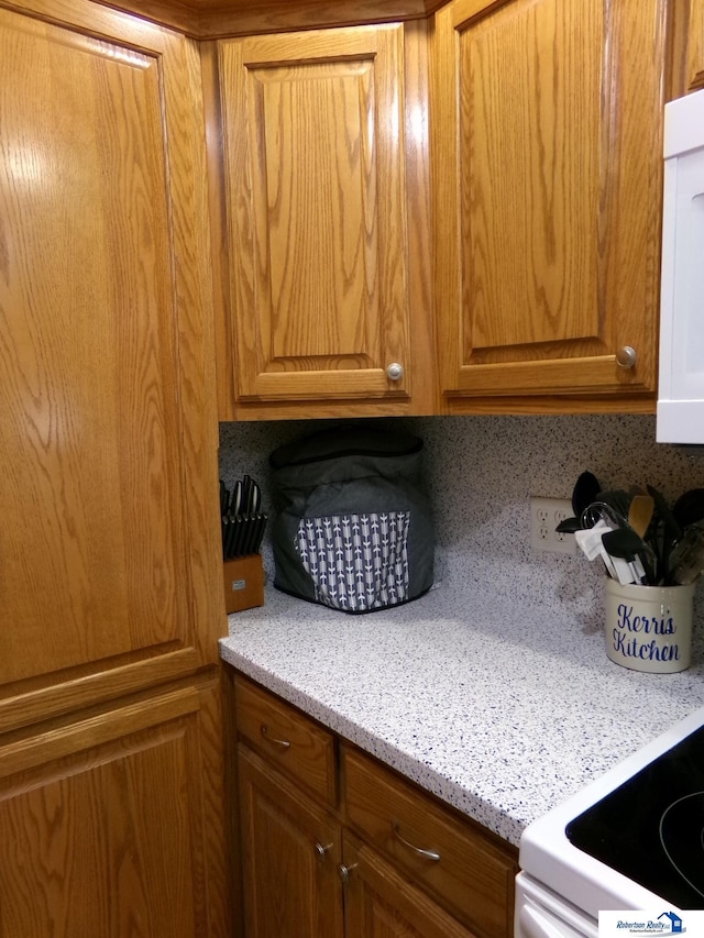 kitchen with brown cabinetry and white electric stove