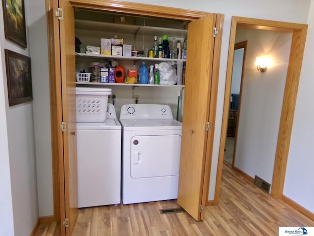 laundry area with visible vents, washer and dryer, light wood-style floors, baseboards, and laundry area