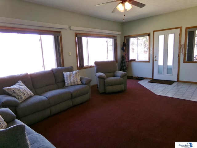 living room with baseboards, light colored carpet, and a ceiling fan