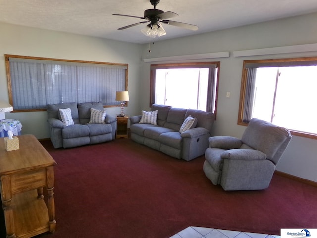 living room with baseboards, plenty of natural light, carpet, and a ceiling fan