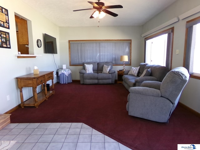 living area with a ceiling fan and baseboards