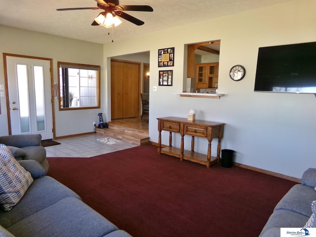 living room with baseboards, carpet floors, a textured ceiling, and a ceiling fan