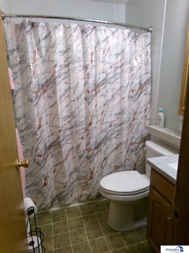 bathroom with tile patterned floors, curtained shower, toilet, and vanity