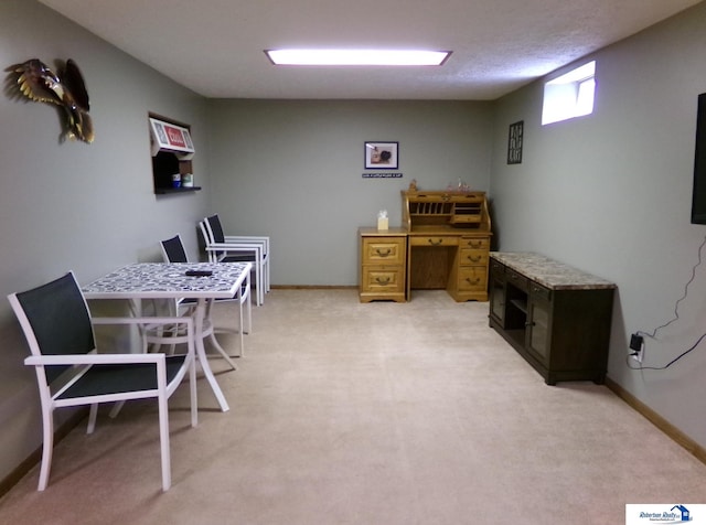 home office with baseboards and light colored carpet