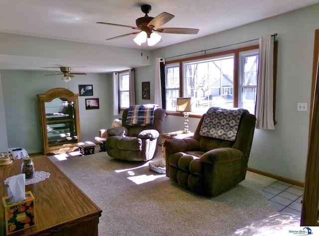 carpeted living area with tile patterned floors, baseboards, and ceiling fan