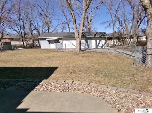 view of yard featuring an attached garage, fence private yard, and driveway