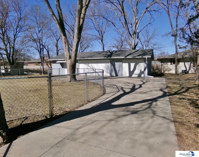 view of front facade featuring concrete driveway and fence