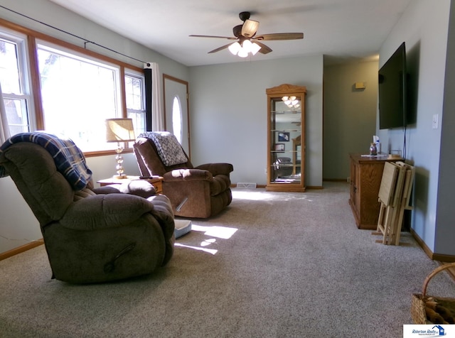 carpeted living area featuring visible vents, baseboards, and ceiling fan