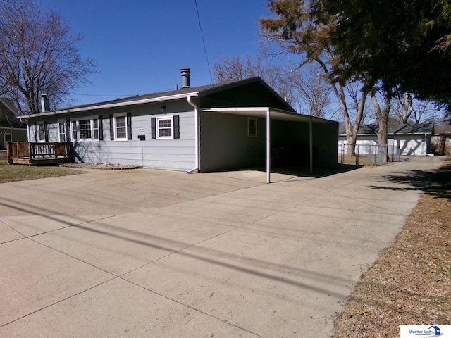 view of front of home with an attached carport, fence, and driveway