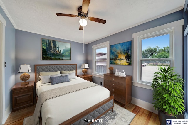 bedroom with baseboards, ornamental molding, light wood-style flooring, a textured ceiling, and a ceiling fan