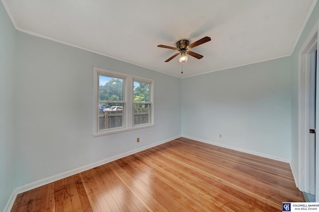 empty room featuring a ceiling fan, light wood-type flooring, baseboards, and ornamental molding