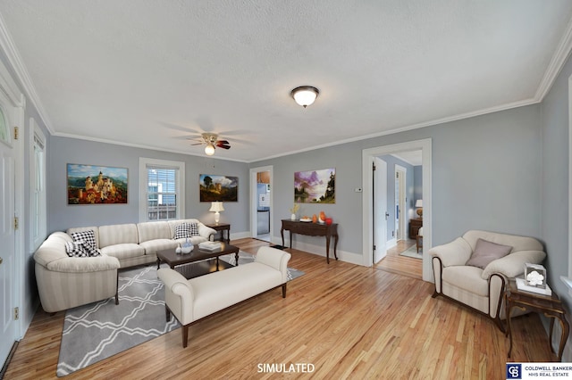 living room featuring light wood-type flooring, baseboards, a textured ceiling, and crown molding