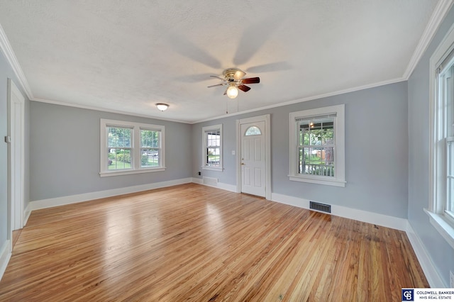 foyer with visible vents, crown molding, baseboards, wood finished floors, and a textured ceiling