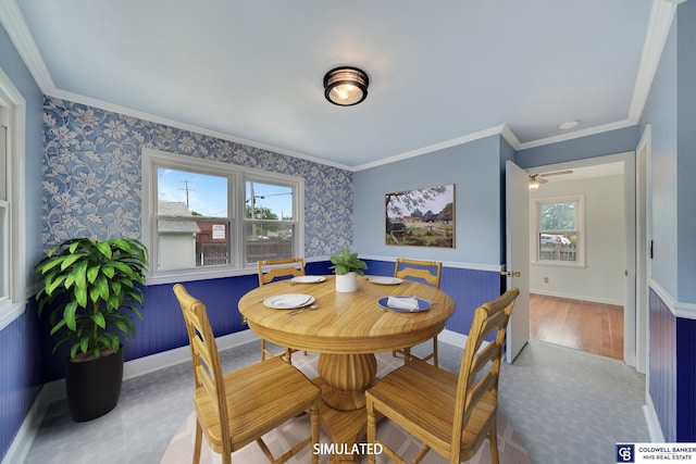 dining area with baseboards, crown molding, wainscoting, and wallpapered walls