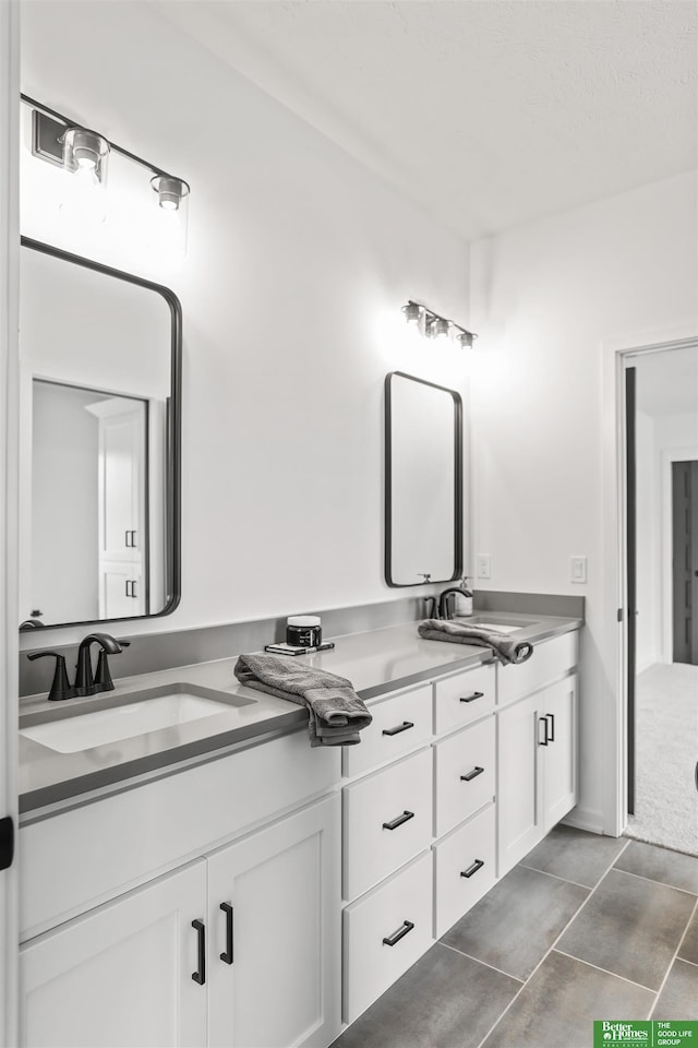 bathroom with tile patterned flooring, a sink, and double vanity