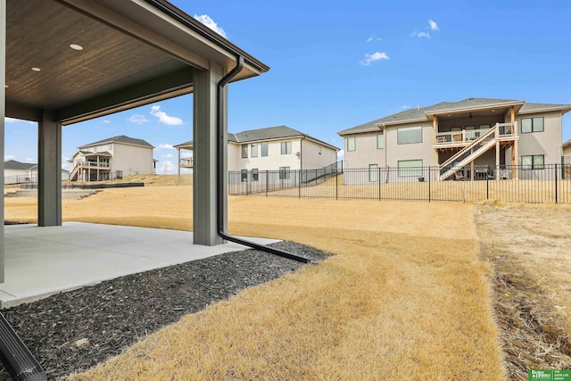 view of yard featuring a patio area, fence, and a residential view