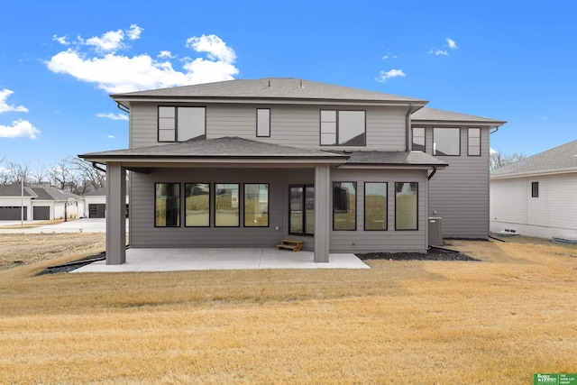 back of house with central air condition unit, a patio area, and a lawn