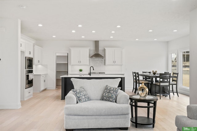 living room with light wood-type flooring, baseboards, and recessed lighting