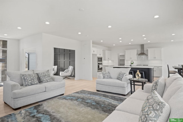 living area featuring light wood-type flooring and recessed lighting