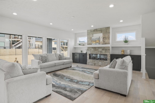 living area featuring light wood finished floors, a multi sided fireplace, and recessed lighting