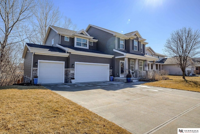 view of front of house featuring a porch, an attached garage, driveway, and a front lawn