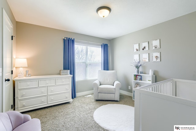 bedroom featuring carpet floors, a crib, and baseboards