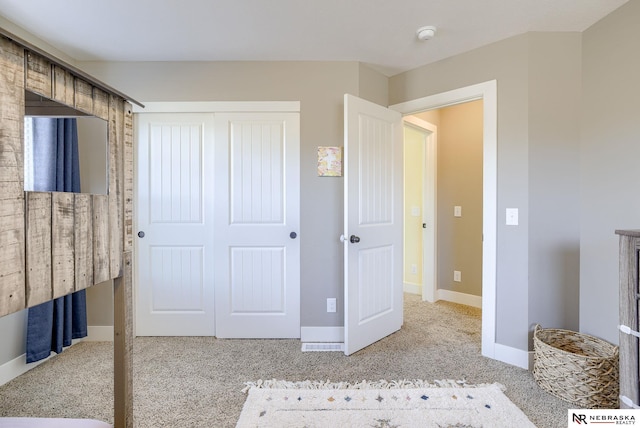 unfurnished bedroom with carpet floors, a closet, and baseboards