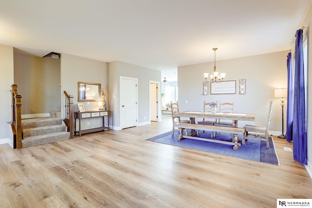 dining room with stairs, light wood finished floors, a notable chandelier, and baseboards