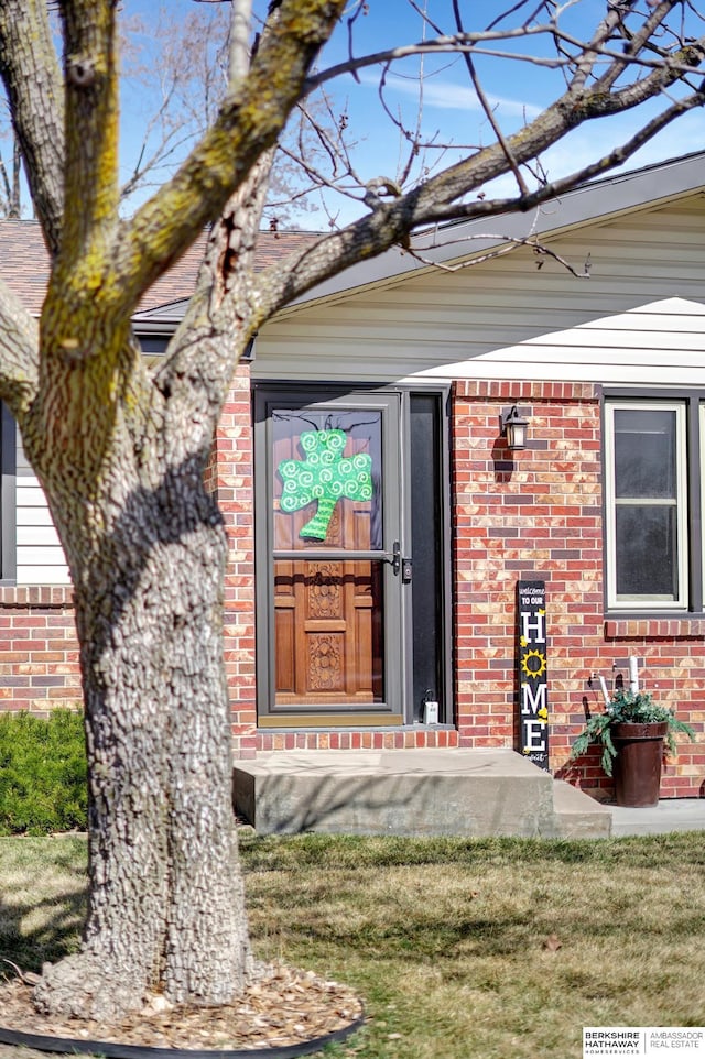 view of exterior entry featuring brick siding