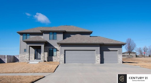 prairie-style home featuring a garage, stone siding, roof with shingles, and driveway