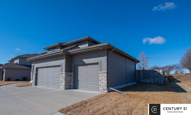 garage featuring driveway and fence