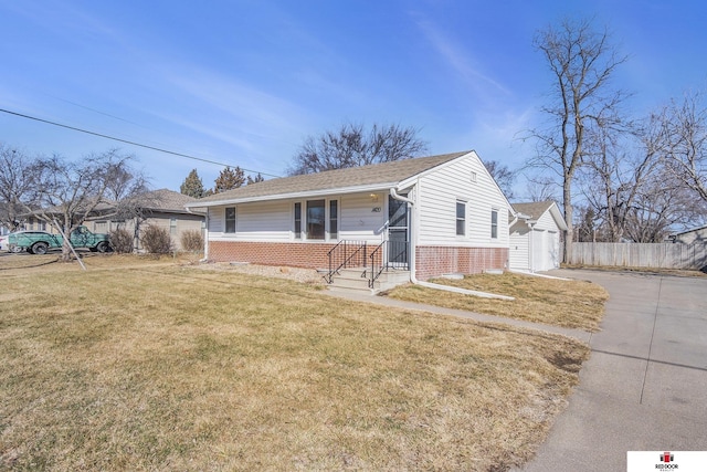 view of front of home with a garage, fence, a front lawn, and brick siding