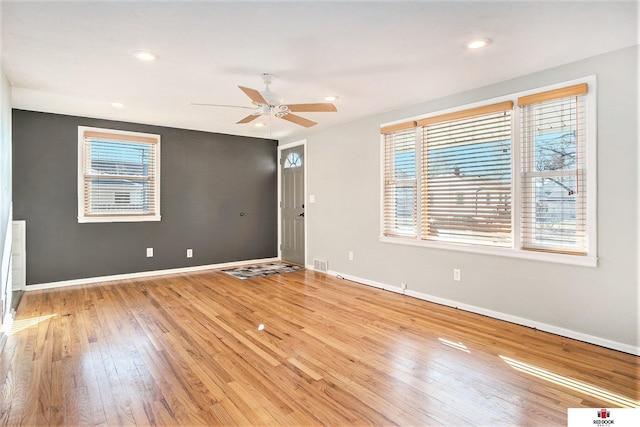 spare room featuring light wood-style floors, recessed lighting, baseboards, and a ceiling fan