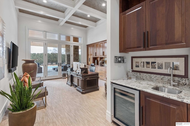 kitchen featuring beam ceiling, beverage cooler, a sink, coffered ceiling, and french doors