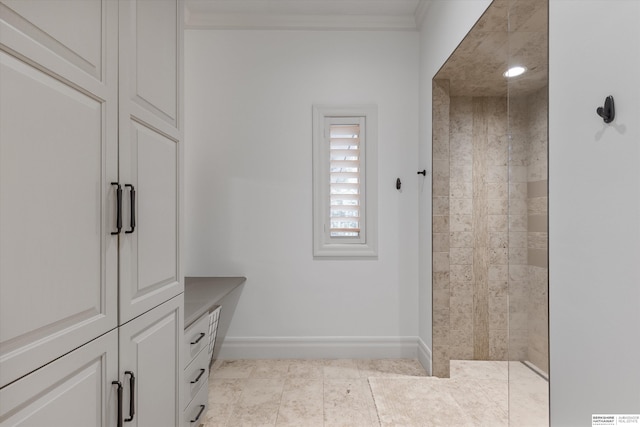 full bath with tile patterned floors, ornamental molding, baseboards, and tiled shower