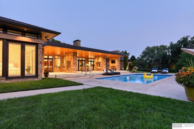 pool with a patio and a yard