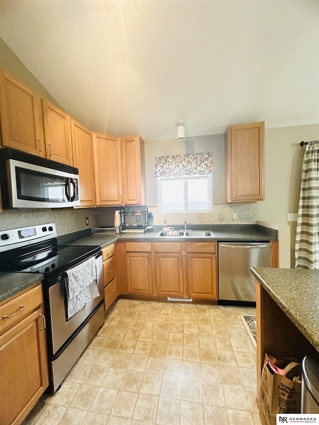 kitchen with a sink, light brown cabinets, and stainless steel appliances