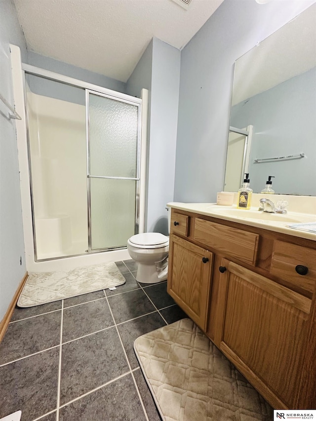 bathroom featuring vanity, a shower stall, toilet, and tile patterned floors