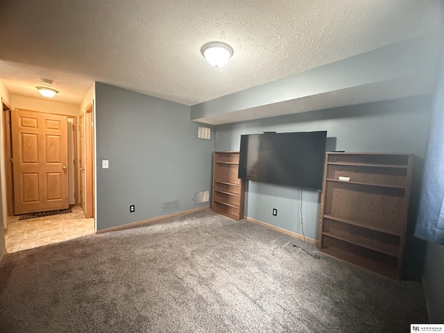 unfurnished living room featuring visible vents, baseboards, a textured ceiling, and carpet flooring