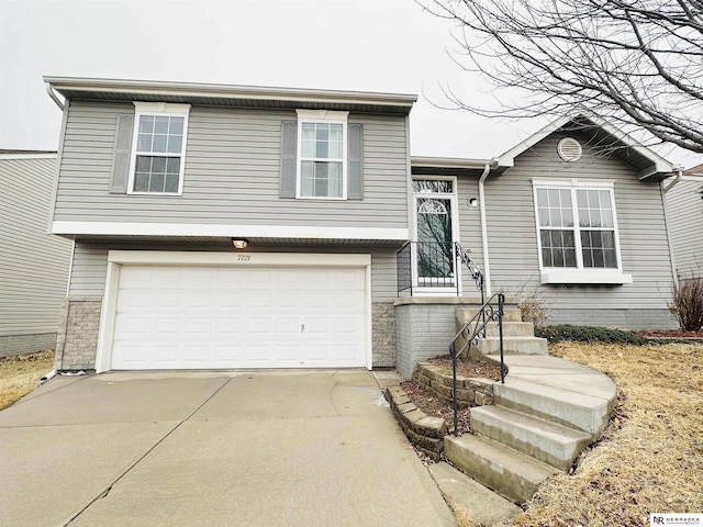 tri-level home featuring an attached garage and driveway