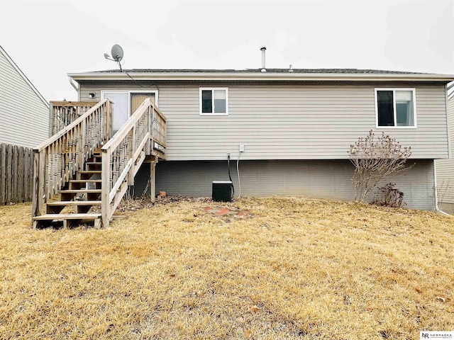 rear view of house featuring stairway, a yard, a wooden deck, and fence