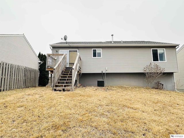 back of house featuring a deck, stairway, fence, and a lawn