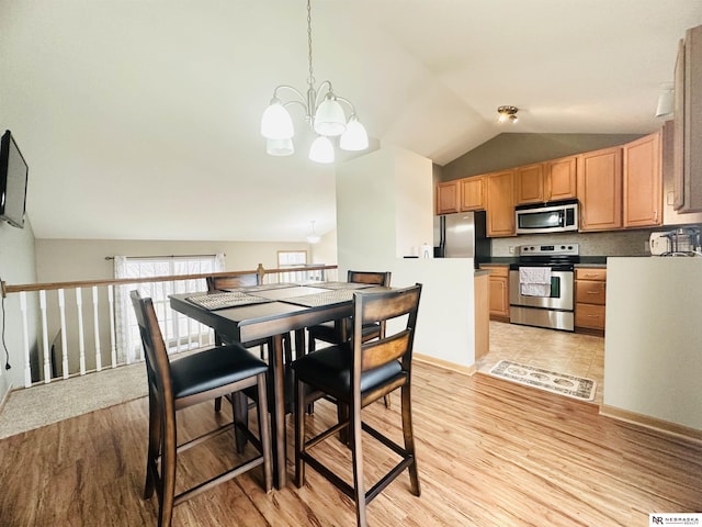 dining space with light wood-style floors, an inviting chandelier, and vaulted ceiling